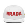 The BRADA fOR LIFE. snapback cap in WHITE, featuring bold red BRADA, combines style with function through its flat brim and small ventilation holes, offering a sleek look accented by a GREY under visor. The BRADA fOR LIFE. snapback cap in WHITE, featuring bold red BRADA, combines style with function through its flat brim and small ventilation holes, offering a sleek look accented by a GREY under visor.