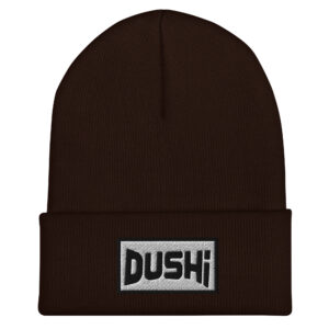 The DUSHI embroidered Cuffed Beanie is a dark brown beanie with a folded brim, featuring a rectangular gray patch with “DUSHI” in bold black letters.
