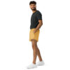 Man in a dark gray top, CHAMP Golden Athletic Shorts, and white sneakers stands smiling against a plain white background. Man in a dark gray top, CHAMP Golden Athletic Shorts, and white sneakers stands smiling against a plain white background.