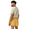 A bearded man in a beige crop top and CHAMP Golden Athletic Shorts stands facing left, gazing sideways. A simple white background accentuates his stylish look. A bearded man in a beige crop top and CHAMP Golden Athletic Shorts stands facing left, gazing sideways. A simple white background accentuates his stylish look.