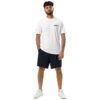 A man with curly hair and a beard stands against a white background, wearing an Under ArmourⓇ athletic t-shirt with BAAS. on the chest, black shorts, and white sneakers, hands by his sides. A man with curly hair and a beard stands against a white background, wearing an Under ArmourⓇ athletic t-shirt with BAAS. on the chest, black shorts, and white sneakers, hands by his sides.