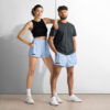 Two people stand side by side in MJL Athletic Shorts, white sneakers, and casual tops—a woman in a black crop top, a man in a dark gray t-shirt. The shorts display the signature MJL initials. Two people stand side by side in MJL Athletic Shorts, white sneakers, and casual tops—a woman in a black crop top, a man in a dark gray t-shirt. The shorts display the signature MJL initials.
