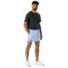 A man with short curly hair and a beard stands against a white background, wearing a dark gray T-shirt, MJL Athletic Shorts in light blue with the initials on the left leg, and white sneakers. A man with short curly hair and a beard stands against a white background, wearing a dark gray T-shirt, MJL Athletic Shorts in light blue with the initials on the left leg, and white sneakers.