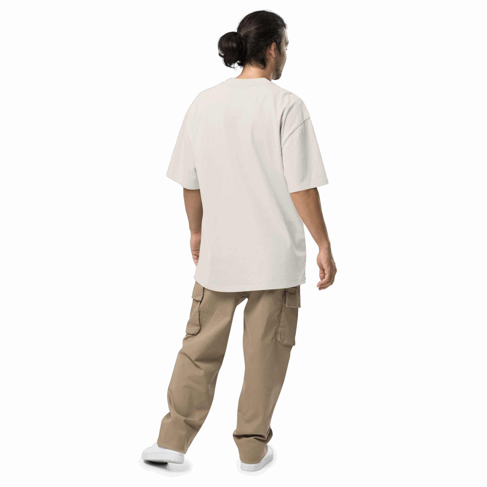 A person with long dark hair in a bun stands facing away, wearing an ADAM XXX TANTOE OUD Oversized faded t-shirt, tan cargo pants, and white shoes against a dark background. A person with long dark hair in a bun stands facing away, wearing an ADAM XXX TANTOE OUD Oversized faded t-shirt, tan cargo pants, and white shoes against a dark background.