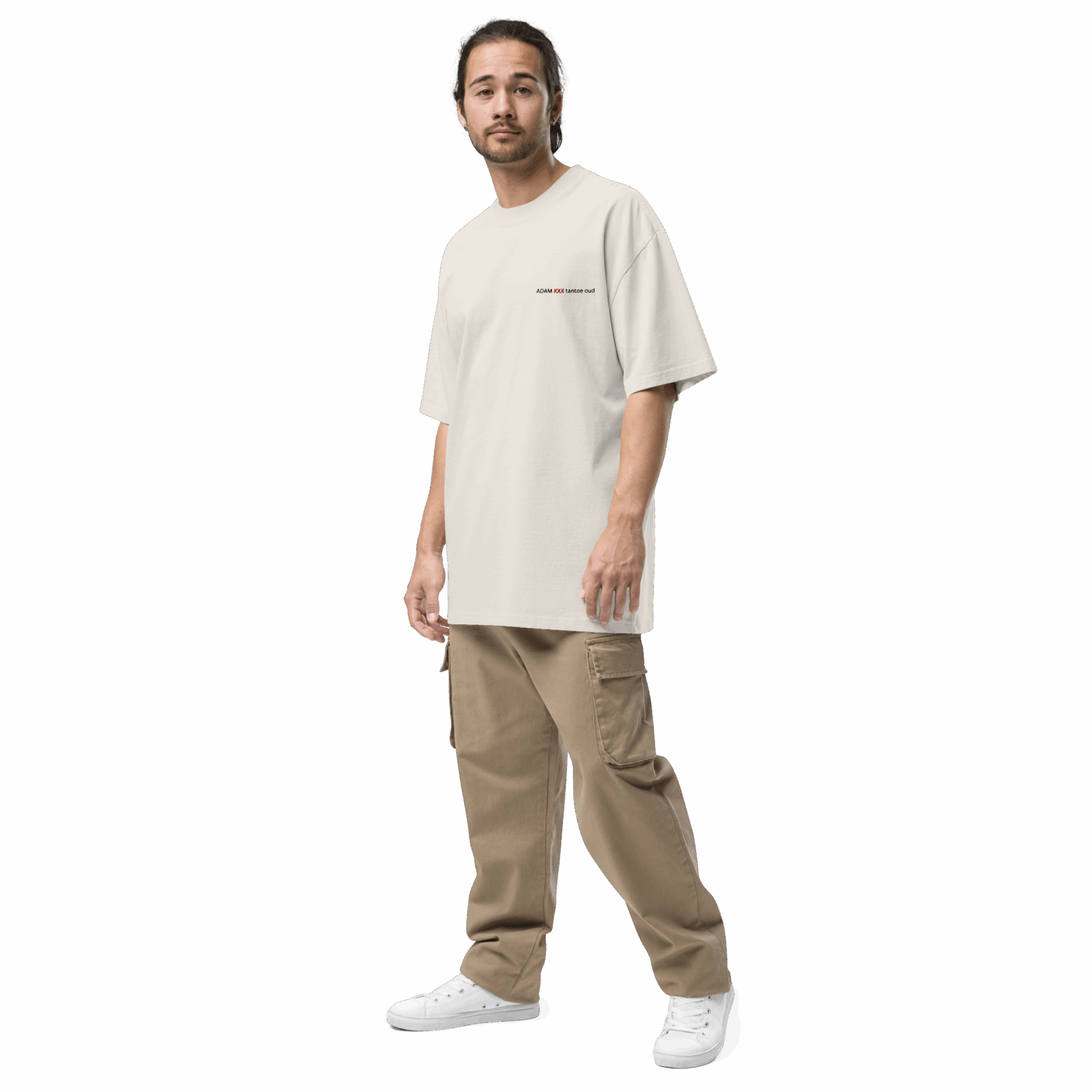 A man with long hair in a ponytail wears an ADAM XXX TANTOE OUD Oversized faded t-shirt, tan cargo pants, and white sneakers, standing against a plain black background. A man with long hair in a ponytail wears an ADAM XXX TANTOE OUD Oversized faded t-shirt, tan cargo pants, and white sneakers, standing against a plain black background.